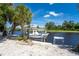 Boat lift with waterfront access and tropical landscaping at 13074 Via Flavia, Placida, FL 33946