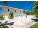 Rear exterior view of home with two-car garage, white fence, and driveway at 13074 Via Flavia, Placida, FL 33946