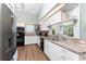 Kitchen boasts stainless steel appliances, white cabinetry, granite counters, and wood-look tile flooring at 13074 Via Flavia, Placida, FL 33946