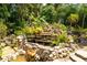 Natural rock water feature surrounded by tropical plants and landscaping at 13074 Via Flavia, Placida, FL 33946