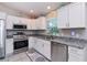 Kitchen with white shaker cabinets, granite counters, and stainless steel appliances at 12112 Helios Ave, Port Charlotte, FL 33981