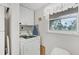 Bright laundry room with washer, dryer, and ample cabinet space at 235 Rotonda Blvd W # C203, Rotonda West, FL 33947