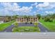 Aerial view of condo building with ample parking and lush landscaping at 235 Rotonda Blvd W # C203, Rotonda West, FL 33947