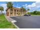 Condo building with parking area and tropical landscaping at 235 Rotonda Blvd W # C203, Rotonda West, FL 33947