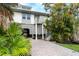 Elevated home with a large, paved driveway, lush landscaping, and golf cart at 7104 Palm Island Dr # Le38, Placida, FL 33946