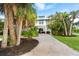 Two-story house with a paved driveway, surrounded by palm trees and tropical landscaping at 7104 Palm Island Dr # Le38, Placida, FL 33946