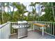 Stainless steel grill and wooden deck with tropical foliage at 7104 Palm Island Dr # Le38, Placida, FL 33946