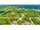 Aerial view showcasing a neighborhood with houses, roads, and a waterway at 9239 Harvester St, Port Charlotte, FL 33981