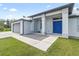 Home exterior featuring a gray metal roof, blue front door, and attached garage at 9239 Harvester St, Port Charlotte, FL 33981
