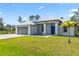 House exterior with gray metal roof, blue door, and landscaped lawn at 9239 Harvester St, Port Charlotte, FL 33981