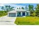 Single-story house with metal roof, attached garage, and a blue door at 9239 Harvester St, Port Charlotte, FL 33981