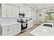 Modern kitchen with white cabinets, quartz countertops, and stainless steel appliances at 9239 Harvester St, Port Charlotte, FL 33981