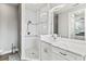 Modern bathroom with walk-in shower, pebble floor, and white cabinets at 9239 Harvester St, Port Charlotte, FL 33981