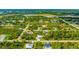 Aerial view of a residential area with houses nestled among green trees at 9239 Harvester St, Port Charlotte, FL 33981