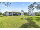 Large backyard with grassy area, shed, and home with covered patio at 9239 Harvester St, Port Charlotte, FL 33981