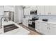 Modern kitchen with white cabinets, quartz countertops, and stainless steel appliances at 9239 Harvester St, Port Charlotte, FL 33981