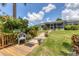 Backyard deck and lawn are surrounded by lush greenery and colorful plants, creating a serene outdoor space at 2516 Dixon Ter, Port Charlotte, FL 33981