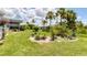 Landscaped backyard features lush green grass and decorative plants in a well-maintained outdoor space at 2516 Dixon Ter, Port Charlotte, FL 33981