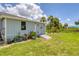 Home exterior features a side view of the building with a small door and beautiful landscaping at 2516 Dixon Ter, Port Charlotte, FL 33981