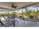 Sunroom featuring tiled floor, ceiling fan and views of the lush tropical landscaping and waterfront canal at 2516 Dixon Ter, Port Charlotte, FL 33981