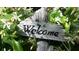 Rustic welcome sign surrounded by white flowers and lush greenery at 3862 59Th W Ave, Bradenton, FL 34210