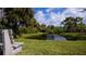 Serene pond with lush landscaping and a peaceful bench at 139 Jose Gaspar Dr # 139, Englewood, FL 34223