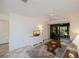 Bright living room with tiled floors, sliding glass doors to patio, and ceiling fan at 139 Jose Gaspar Dr # 139, Englewood, FL 34223