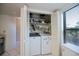 Small laundry room with washer and dryer and storage shelves at 139 Jose Gaspar Dr # 139, Englewood, FL 34223