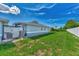 Large grassy backyard with a white vinyl fence and AC unit at 6551 Hamlet Dr # 22A, Englewood, FL 34224