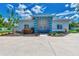 Single story home with teal accents and landscaping at 6551 Hamlet Dr # 22A, Englewood, FL 34224
