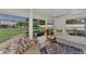 Peaceful screened porch, wicker furniture, and lush green view at 6551 Hamlet Dr # 22A, Englewood, FL 34224