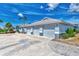 Triple-car garage with gray doors and a concrete driveway at 6551 Hamlet Dr # 22A, Englewood, FL 34224