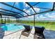 Peaceful pool and lanai with wicker chairs, screened enclosure, and scenic views at 16147 Lankford Ct, Port Charlotte, FL 33981