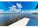 White dock extends over calm water with views of lush greenery and a blue sky at 16147 Lankford Ct, Port Charlotte, FL 33981