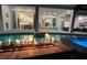Fire pit with flames reflecting in the pool; view into the home's interior at 16147 Lankford Ct, Port Charlotte, FL 33981