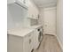 Laundry room with white shaker cabinets, quartz countertops, and a modern washer and dryer at 16147 Lankford Ct, Port Charlotte, FL 33981