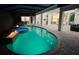 Night view of a freeform pool with fire features and a view into the home at 16147 Lankford Ct, Port Charlotte, FL 33981