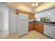Kitchen with wood cabinets and white appliances at 23465 Harborview Rd # 1021, Punta Gorda, FL 33980