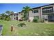 Exterior view of a condo building with lush landscaping at 23465 Harborview Rd # 1021, Punta Gorda, FL 33980