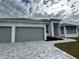 Modern home with three-car garage and a gray paver driveway at 8356 Tecumseh Cir, Port Charlotte, FL 33981