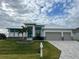 Modern home with three-car garage, stone accents and landscaping at 8356 Tecumseh Cir, Port Charlotte, FL 33981