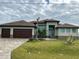 House with two-car garage and a paved driveway at 8356 Tecumseh Cir, Port Charlotte, FL 33981