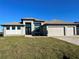 Two-story home with three-car garage, and landscaped lawn at 8356 Tecumseh Cir, Port Charlotte, FL 33981