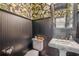 Stylish powder room with dark wood and tropical wallpaper at 13310 Anglers Way, Placida, FL 33946
