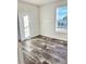 Bright bedroom with wood-look floors and window at 1377 Ibis Dr, Englewood, FL 34224