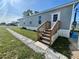 Side view of single-Gathering home featuring stone walkway, small garden, and wooden stairs to the front door at 1377 Ibis Dr, Englewood, FL 34224