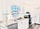 Modern kitchen with white cabinets, granite counters, and stainless appliances at 1377 Ibis Dr, Englewood, FL 34224