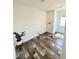 Bright mud room featuring wood-look flooring, white walls, and a modern plant in a white ceramic pot at 1377 Ibis Dr, Englewood, FL 34224