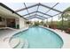 Inviting screened-in pool with pristine blue water, a relaxing retreat with lush landscaping at 3440 Downing W St, Englewood, FL 34224