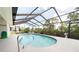 Inviting screened-in pool with pristine blue water, a relaxing retreat with lush landscaping at 3440 Downing W St, Englewood, FL 34224